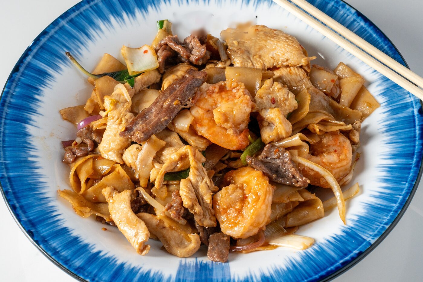 Drunken Noodles with wide rice noodles and Thai basil - East Moon Centennial CO
