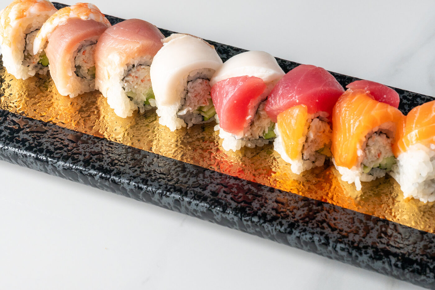 Rainbow Roll topped with tuna, salmon and yellowtail - East Moon Centennial CO