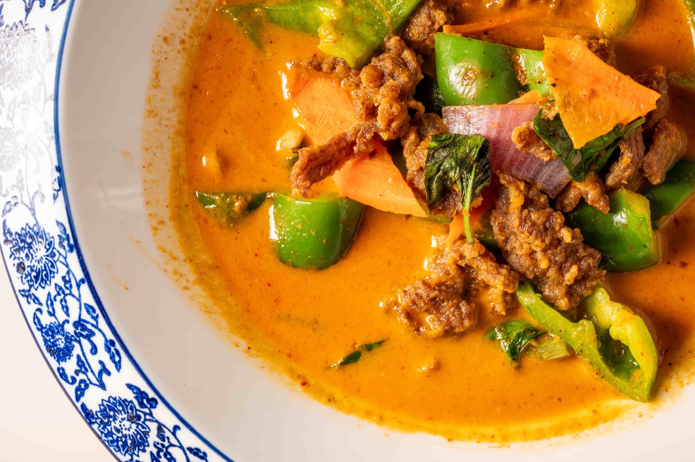 Panang red curry slow cooked with coconut milk, kaffir lime leaves, basil, bell pepper and sweet potato - East Moon Centennial CO
