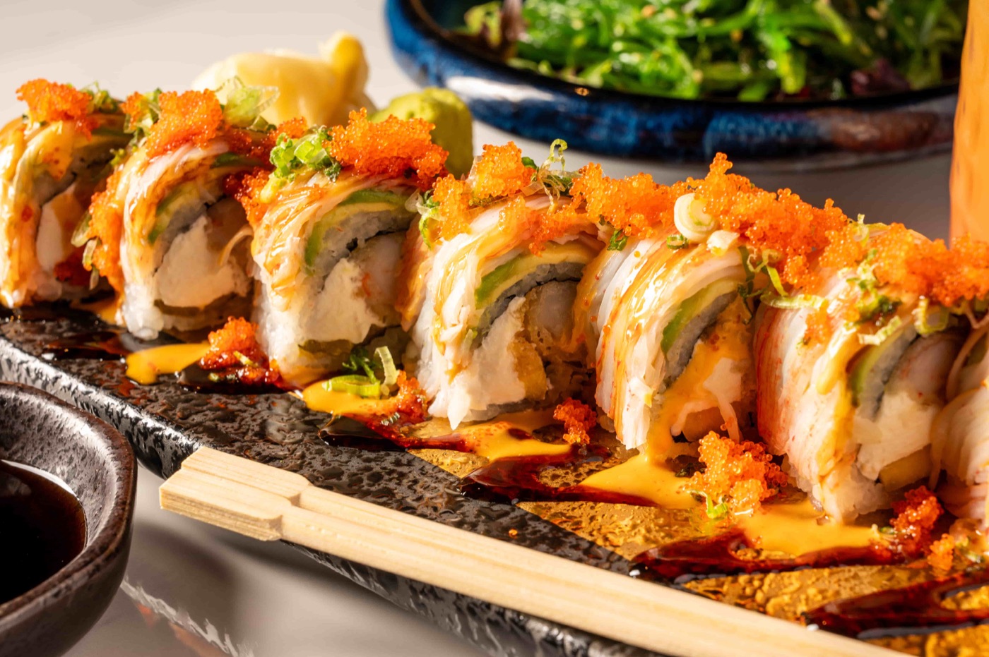 Phoenix Roll with shrimp tempura, cream cheese and mango topped with avocado and crabmeat - East Moon Centennial CO